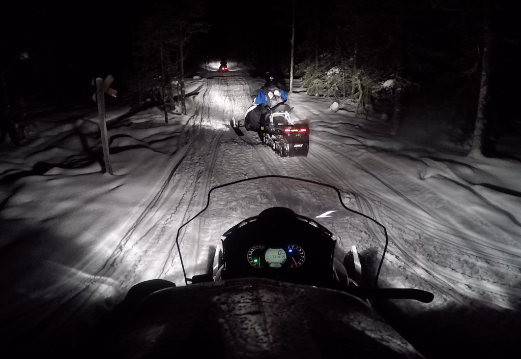 En motos de nieve por los paisajes nevados de Laponia finlandesa.
